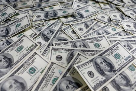 Dollar clings to modest gains as strong U.S. data lends support
